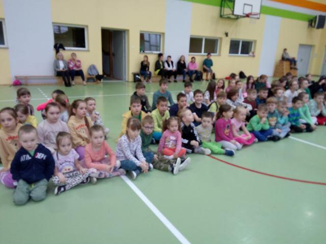 dzieci siedzą na sali gimnastycznej